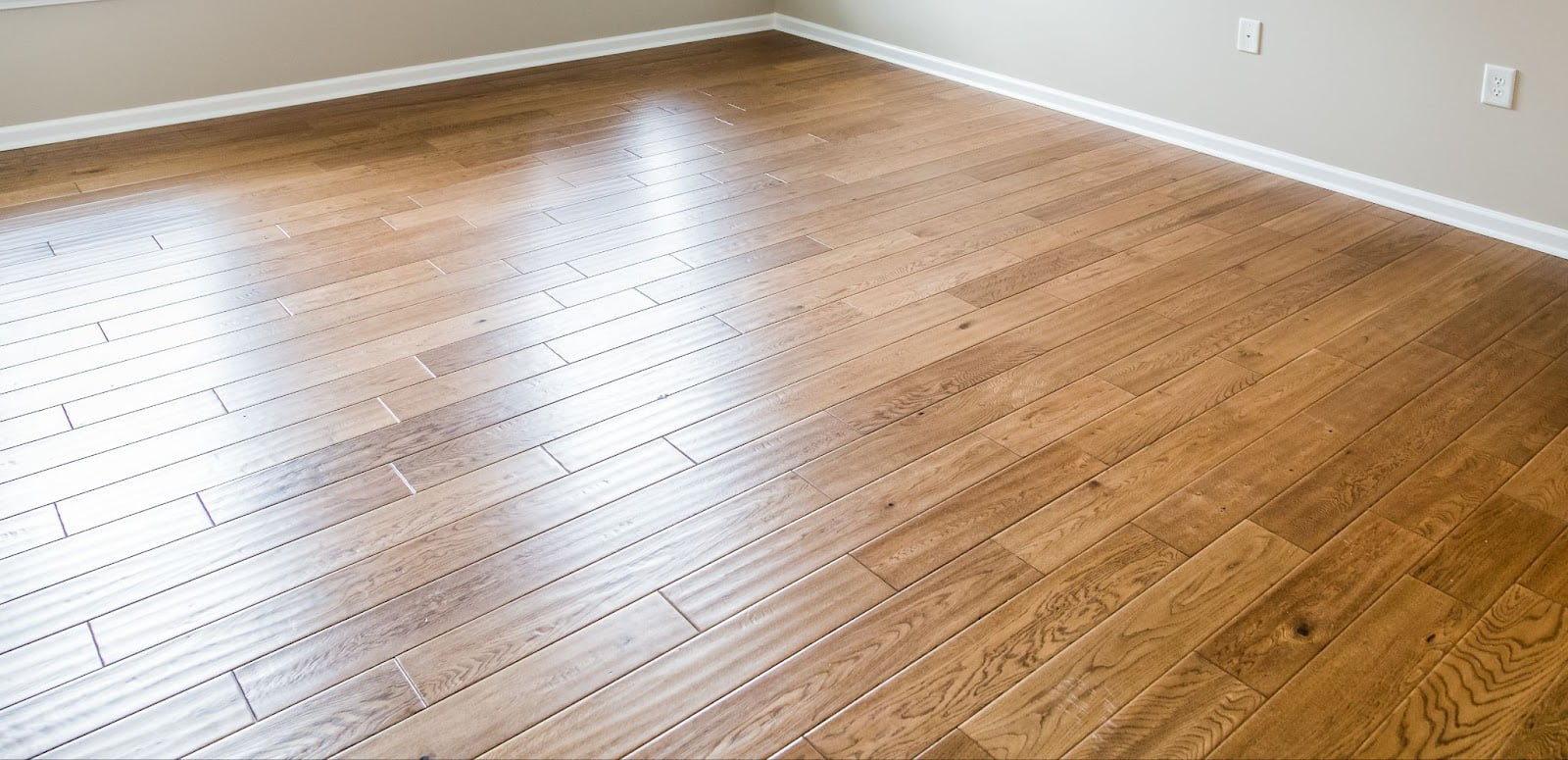 A clean hardwood floor in a room with carpet flooring and hardwood flooring.