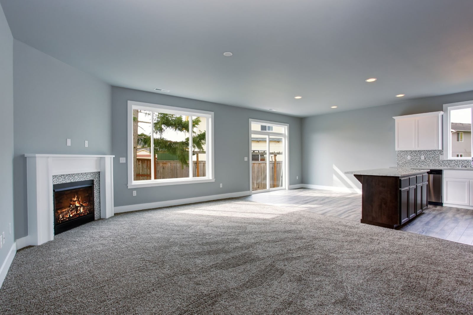 Living room with fireplace and kitchen, wood flooring in Utah, featuring new hardwood flooring.